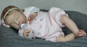Close-up of 19 inch sleeping reborn baby doll in pink cat outfit with floral headband