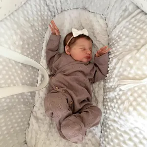 Lifelike 20-inch Reborn Baby Doll Laura in mauve knit romper sleeping on minky bedding