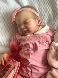 Détail d'une poupée Reborn dormante de 19 pouces en robe rose avec un lapin en peluche doux