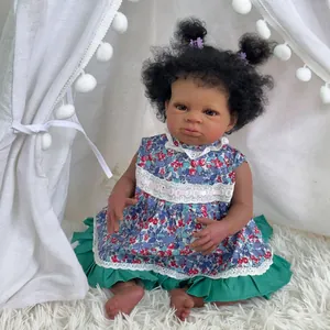 Bambola reborn nera realistica da 50cm con capelli ricci seduta su tappeto di peluche