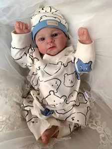 Close-up of Elijah reborn baby doll in cream bear romper on soft lace background