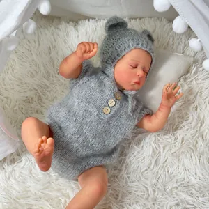 Realistic 49cm reborn newborn baby doll in grey knitted outfit sleeping on plush rug