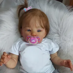 Gros plan d'une poupée reborn avec yeux bleus et nœud en dentelle rose sur les cheveux