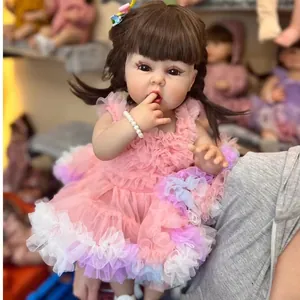 Lifelike 55cm reborn girl doll in pink lace dress with brunette pigtails and pearl bracelet