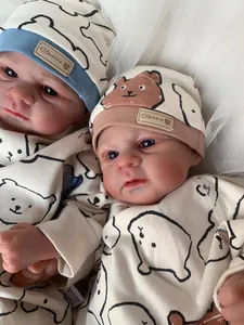 Close-up of Elijah reborn baby doll in bear print bodysuit with classic label hat