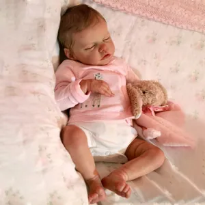 Primer plano de muñeca reborn realista de 18 pulgadas durmiendo con ropa de rayas rosas