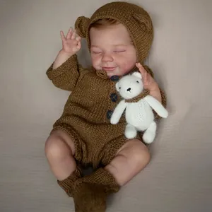 Realistic 49cm reborn baby doll April wearing brown knit outfit with small bear toy
