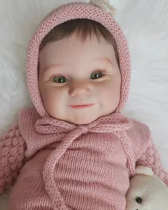 Gros plan de la poupée Maddie réaliste de 60cm avec cils et pull en tricot rose tendre