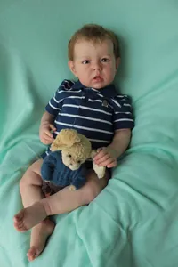 Close-up of 75cm realistic Liam reborn doll with 3D skin texture and blue striped polo shirt
