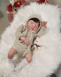 Lifelike Reborn Baby Doll in beige knitted outfit sleeping on a soft white plush rug