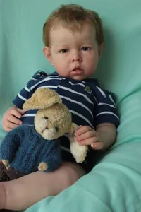 Detailed realistic reborn baby doll Liam with lifelike 3D skin and knit rabbit toy