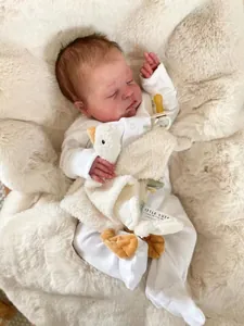 Detailed close-up of a lifelike 49cm reborn baby doll with a white duck comforter toy