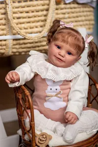 Close-up of Maddie reborn doll with curly hair, blue eyes and pink rabbit romper