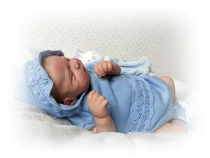 Macro detail of 48cm realistic reborn doll in blue knit set with bunny plush toy