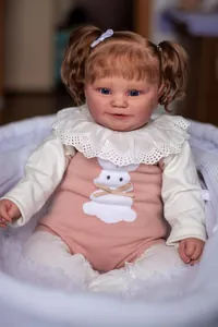 Close-up of Maddie reborn doll with curly hair sitting in a white woven basket