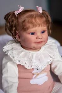 Close-up of 60cm reborn doll Maddie featuring brown curls and blue acrylic eyes