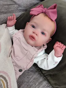 Detail of 55cm realistic reborn baby doll wearing a pink headband and floral outfit