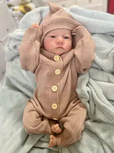 Close-up of realistic Levi reborn doll in brown knit hooded romper on blue blanket