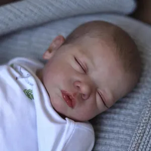 Realistic 48cm reborn baby doll in white cotton romper sleeping on grey knit blanket