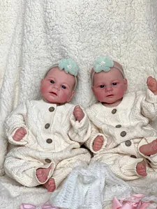 Lifelike 46cm Elijah reborn baby doll in cream knit romper on white fleece background