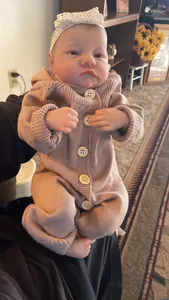 Detail of 49cm reborn doll Levi featuring realistic skin folds and pink knit romper