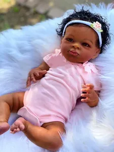 Detalle de una muñeca Reborn africana realista con ropa rosa y diadema de flores