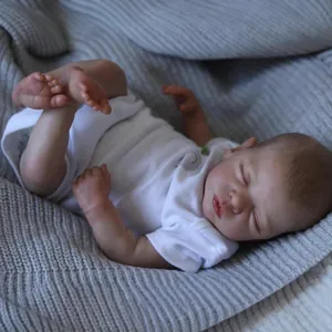 Realistic 48cm reborn baby doll in sleeping pose wearing white bodysuit on knit blanket