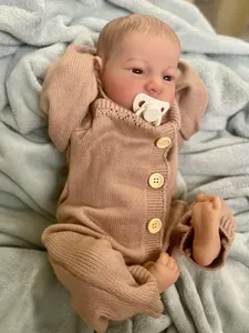 Close-up of lifelike newborn reborn doll Levi with realistic skin texture and knitted outfit