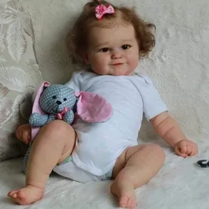 Détail d'une poupée reborn réaliste de 50 cm avec un lapin en peluche et un nœud rose