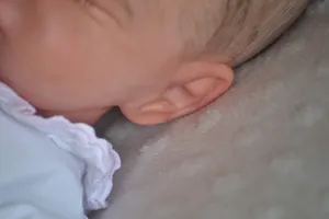 Detailed close-up of reborn doll Rosalie with 3D skin texture and soft hand-painted hair