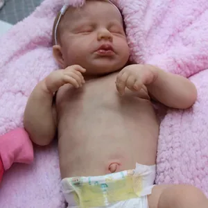 Realistic 49cm reborn baby doll LouLou sleeping with pink headband on soft plush rug