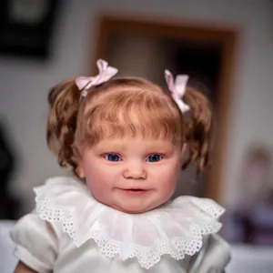 Realistic 60cm baby doll Maddie with brown curly hair, blue eyes and pink headband bow