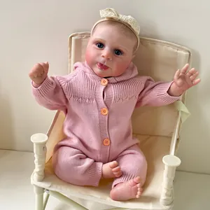 Bambola neonata realistica Sebby di 49cm in pagliaccetto rosa e fascia in pizzo