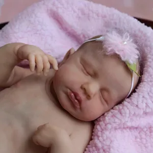 Realistic reborn baby doll LOULOU sleeping in a soft pink blanket with flower headband