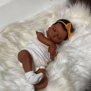 49cm reborn doll with dark skin tone and sleeping expression on plush white background