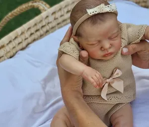 Detail of 49cm reborn baby doll Romy with 3D skin texture and beige knit outfit