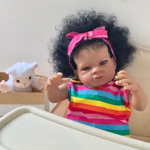 Poupée Reborn de 50cm à peau foncée portant un gilet arc-en-ciel et un bandeau rose avec agneau