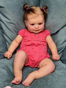 Detailed view of handmade reborn baby doll with pigtails and pink polka dot outfit