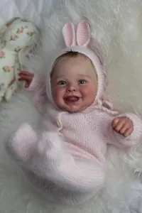 Détail de la poupée Harper avec gilet rose tricoté et bonnet oreilles de lapin sur fourrure