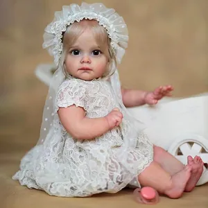 Realistic Toddler Maggi reborn doll in white lace dress with bonnet and pink pacifier