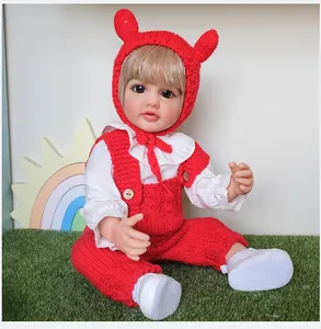 Close-up of 55cm realistic reborn doll wearing red knit bunny hat and overalls