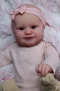 Dettaglio della bambola Maddie realistica con occhi marroni e vestito rosa in maglia