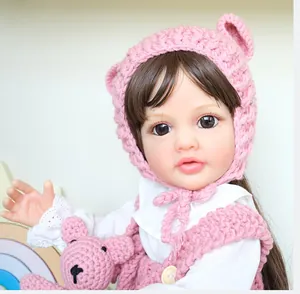 Close-up of a 55cm Betty reborn doll wearing a pink knitted hoodie with bear details