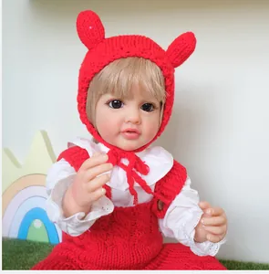 Detail of reborn baby doll Betty wearing a red knitted outfit and lace shirt