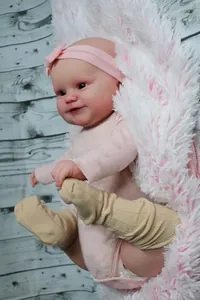 Dettaglio della bambola Maddie di 50cm con vestito rosa su coperta morbida