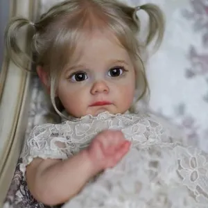 Realistic toddler reborn doll Maggi with blonde pigtails in a white lace dress