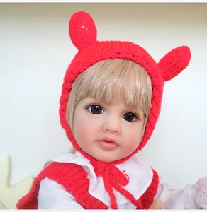 Close-up of Betty reborn baby doll wearing a red knit hat with ears and lace shirt
