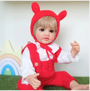 Close-up of 55cm realistic baby doll wearing a red knitted outfit and white shirt