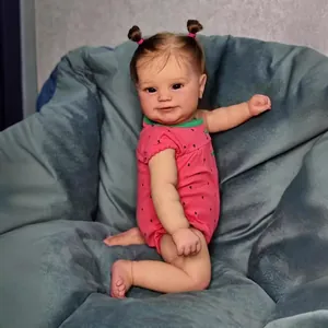 50cm lifelike reborn baby doll Maddie in pink strawberry romper on soft cushion