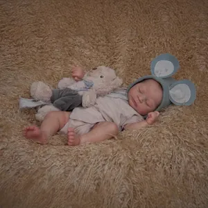 Realistic 49cm reborn baby doll with visible veins wearing a knit hat and romper